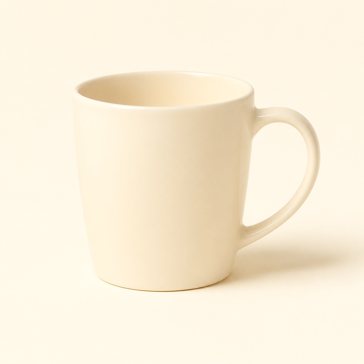A mug glazed entirely in cosmic latte — body, rim, handle and interior all one pale warm cream, on a ground of the same color